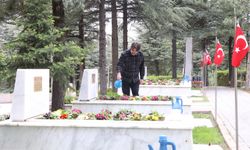 Güvenlik görevlisi şehit mezarlarının bakımlarını yapıyor