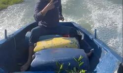 Sular altında kalan bahçesine kayıkla gitti