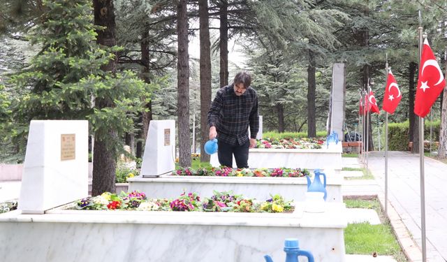 Güvenlik görevlisi şehit mezarlarının bakımlarını yapıyor