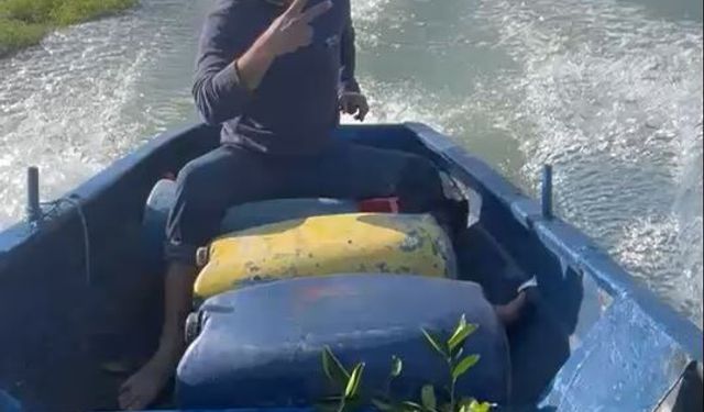 Sular altında kalan bahçesine kayıkla gitti